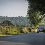 A Volvo car drives along a countryside road